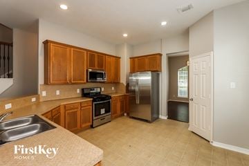 Spring house for rent - A kitchen with wooden cabinets and a stainless steel refrigerator.