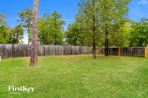 Spring house for rent - A grassy field with trees and a wooden fence.