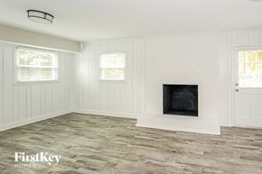 Monroe house for rent - a living room with a fireplace and a wooden floor