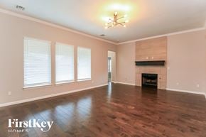Edmond house for rent - an empty living room with a fireplace and wooden floors