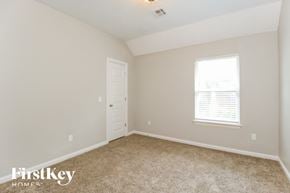 Edmond house for rent - a bedroom with carpet and a white door and window