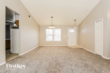 Apopka house for rent - a spacious living room with carpet and a door to the kitchen