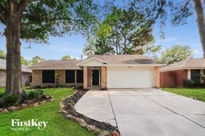 Kingwood house for rent - a small brick house with a driveway and a tree