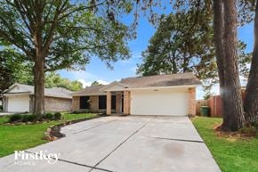 Kingwood house for rent - a house with a driveway and trees in front of it