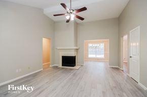Kingwood house for rent - a living room with a fireplace and a ceiling fan