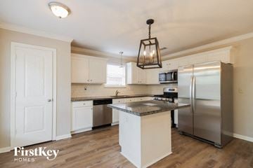 Kingwood house for rent - a kitchen with white cabinets and stainless steel appliances and a counter top