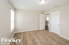 Green Cove Springs house for rent - a bedroom with a carpeted floor and a door to a hallway