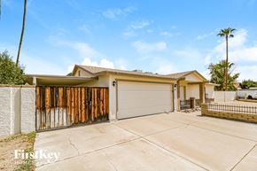Glendale house for rent - A house with a garage and a fence in front of it.
