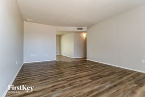 Glendale house for rent - A spacious room with wooden flooring and white walls.