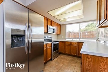 Glendale house for rent - A kitchen with a stainless steel refrigerator and wooden cabinets.