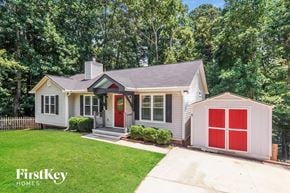 Cumming house for rent - a small house with a red garage door and a lawn