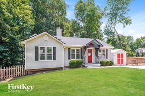 Cumming house for rent - a small white house with a red door and a yard