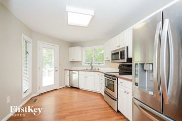 Miami Twp house for rent - A kitchen with a refrigerator, microwave, and oven.