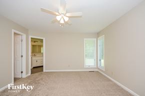 Miami Twp house for rent - A spacious room with a ceiling fan and a carpeted floor.