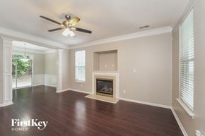 Charlotte house for rent - an empty living room with a fireplace and a ceiling fan