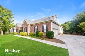Advance house for rent - a large brick house with a driveway and lawn