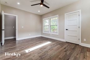 Atlanta house for rent - an empty living room with a white door and a ceiling fan