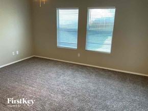 Fort Worth house for rent - a carpeted room with two windows in it