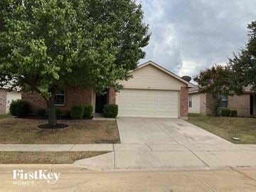 Fort Worth house for rent - a house with a driveway and a tree in front of it