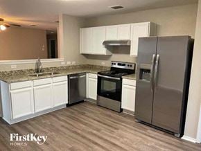 Fort Worth house for rent - a kitchen with stainless steel appliances and white cabinets