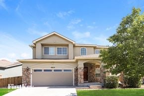 Commerce City house for rent - A house with a garage and a driveway in front of it.
