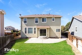 Commerce City house for rent - A house with a grey exterior and a brown roof is shown.