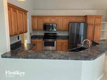 North Port house for rent - a kitchen with granite counter tops and wooden cabinets