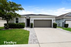 Orlando house for rent - A house with a garage and a tree in front of it.