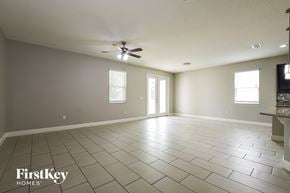 Orlando house for rent - A spacious room with a fan and tile flooring.