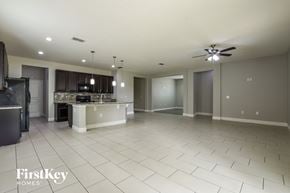Orlando house for rent - A spacious kitchen and living room with a white tile floor and a ceiling fan.