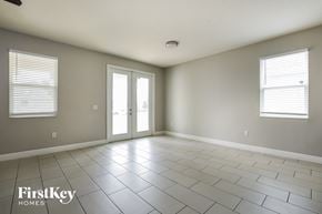 Orlando house for rent - A spacious room with tile flooring and two windows.