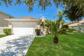Orlando house for rent - A white house with a garage door and a palm tree in front.