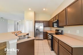 Orlando house for rent - A kitchen with brown cabinets and a stainless steel refrigerator.