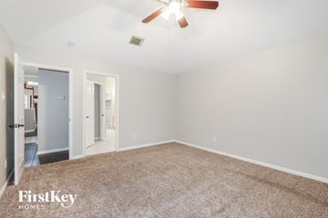 Spring house for rent - a spacious living room with carpet and a ceiling fan