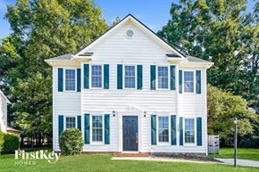 Durham house for rent - A white house with a black door and green shutters.