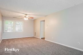 Durham house for rent - A room with a carpet floor, a ceiling fan, and a door.