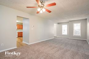 Durham house for rent - A spacious room with a ceiling fan and carpeted floor.