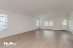 San Antonio house for rent - A spacious room with wooden flooring and two windows.