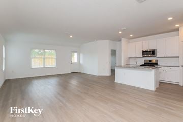San Antonio house for rent - A spacious kitchen and living room with white cabinets and a wooden floor.