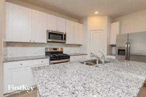 San Antonio house for rent - A kitchen with granite countertops and white cabinets.