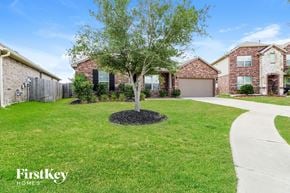 Katy house for rent - A tree in a mulched area in front of a house.