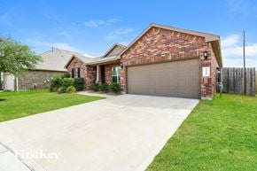 Katy house for rent - A brick house with a garage door and a driveway.