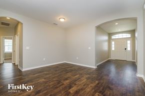 Lakeland house for rent - A spacious room with wooden floors and white walls, branded with "FirstKey Homes".