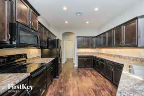 Lakeland house for rent - A kitchen with black appliances and wooden floors.