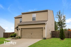 Cartersville house for rent - a house with a garage door and a lawn