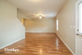 Cartersville house for rent - a empty living room with a wood floor and a ceiling fan