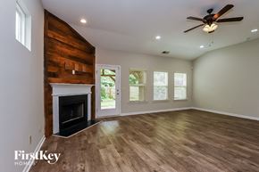 Ball Ground house for rent - A spacious room with a fireplace and a ceiling fan.