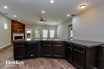 Ball Ground house for rent - A kitchen with dark wood cabinets and a wooden accent wall.