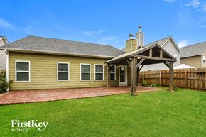 Ball Ground house for rent - A house with a covered patio and a brick walkway.