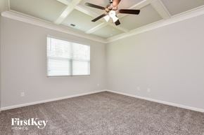 Covington house for rent - the master bedroom has a ceiling fan and a carpeted floor